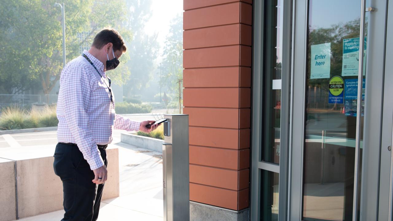 Jeff Rott, the Director of Security at UC Davis Police, uses an AggieAccess mobile credential at a card reader outside California Hall